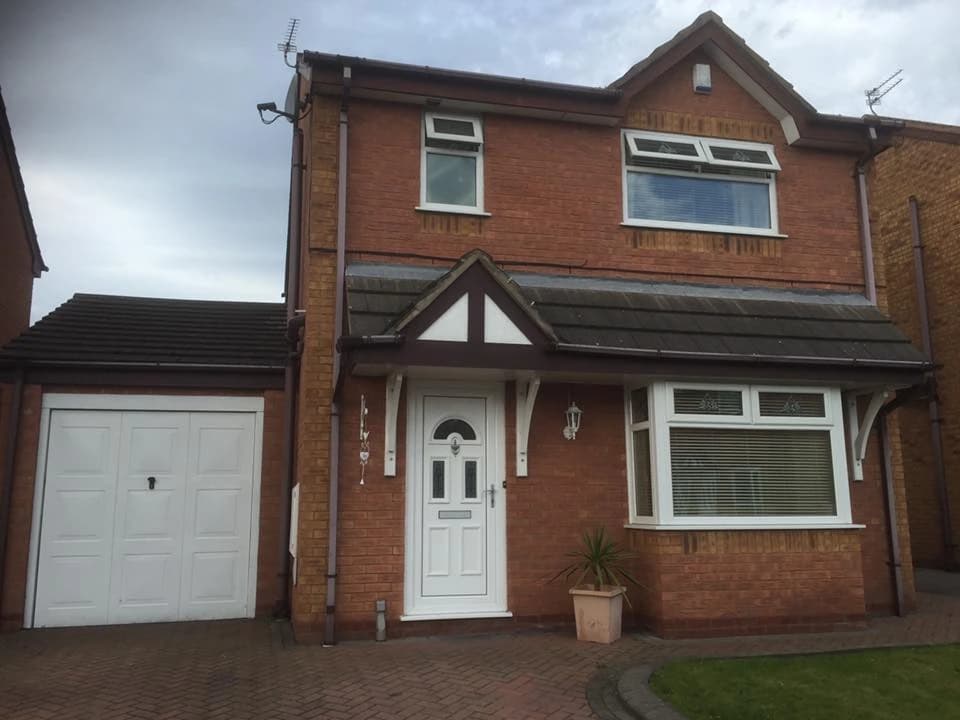 Completed UPVC guttering installation on a red-brick Liverpool property with garage, by Sefton Roofing